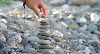 Imagem de Uma pessoa empilhando pedras