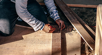 Imagem de Man measuring boards of wood